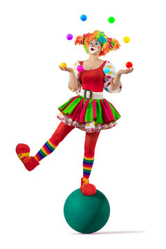 Funny juggler female clown juggling balls in the circus, woman entertainer as Joker in suit and wig, with clown whiteface makeup. Trickster, jester, pantomime, mime, and a professional actor at events