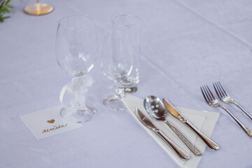 Wedding table with detail of glasses, cutlery and signs with name tags in the Czech language