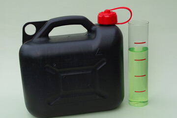 Black tank, glass with biodiesel and rapeseed plant. Biodiesel day concept