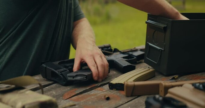 5.56 bullets being grabbed and loaded into a magazine