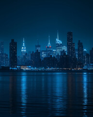 Fototapeta premium A dramatic night view of a city skyline reflected on calm water