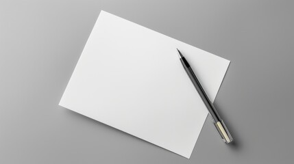 White paper and pen on gray background with space for text top down view of work area