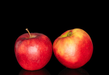 Two red apples, macro, isolated on black background.