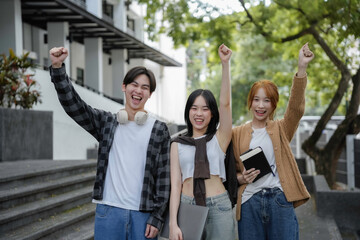 Obraz premium Three enthusiastic students triumph outside university building, raising their fists in joy and celebration