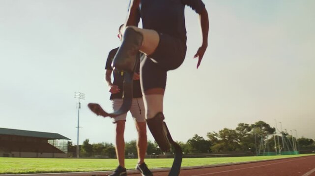 Black Para-runner on the track with his training coach