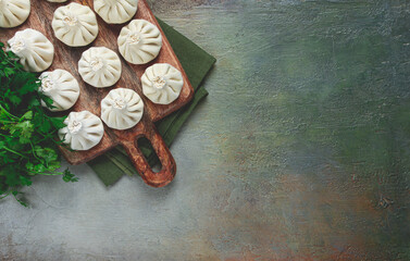 freshly frozen raw khinkali, on a wooden chopping board, top view, Georgian cuisine, no people,