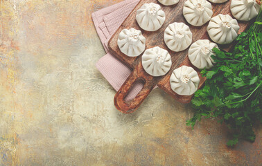 freshly frozen raw khinkali, on a wooden chopping board, top view, Georgian cuisine, no people,