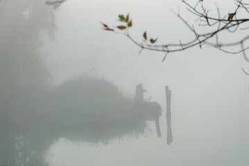 Fog on the river in the early morning and a fisherman, autumn background.