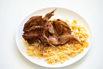 Quail prepared on a plate with pasta and egg crumbs