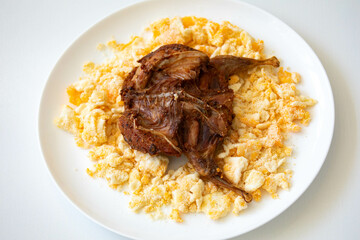 Quail prepared on a plate with pasta and egg crumbs