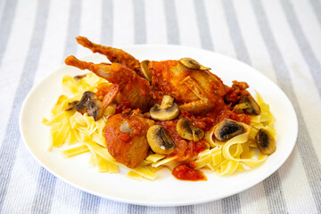 Quail prepared on a plate with pasta and egg crumbs