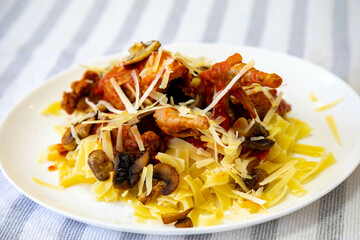 Quail prepared on a plate with pasta and egg crumbs