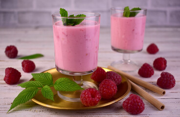 Raspberry smoothie with mint on a white wooden background.	