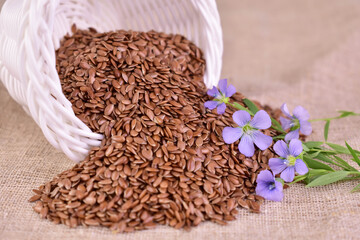 Flax seeds are poured out of a cup. Close-up.
