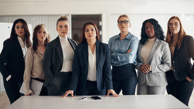 Diverse group of successful businesswoman standing in an office boardroom