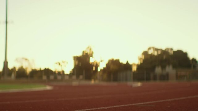 Para-runner with his Prosthetic legs on the racing track at sunset