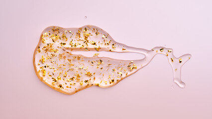 Cosmetic serum with 24k gold on a pink background.