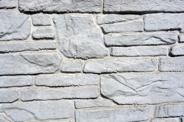 Building materials, gray concrete cement fence made in the form of natural drilled stones.