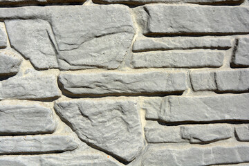 Building materials, gray concrete cement fence made in the form of natural drilled stones.