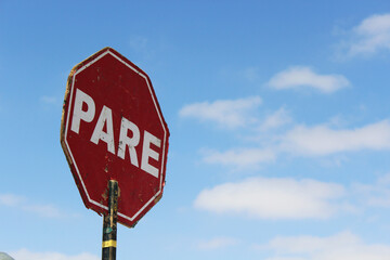 Stop sign in Spanish with blue sky in the background
