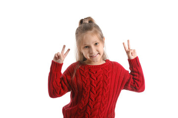 Cute little girl in knitted sweater showing victory gesture on white background