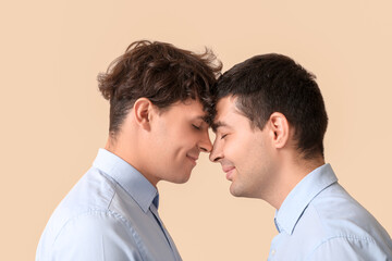 Married gay couple on beige background, closeup