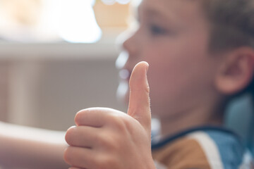 Boy showing thumbs up close-up