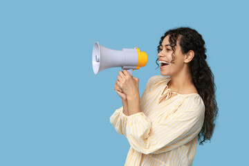 Young African-American woman with megaphone on blue background