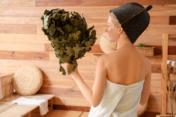 Young woman with whisk in sauna, back view
