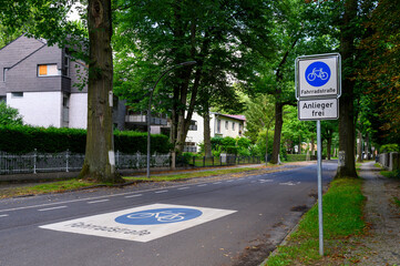 Road sign that gives cyclists priority over cars. Below the bicycle icon, it says bicycle street in German. The additional sign says in German that only residents are allowed to use the road by car.