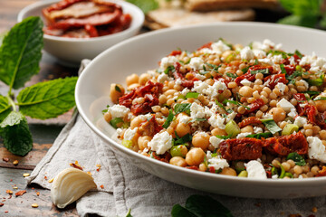 Pearl Couscous salad with sun dried tomatoes, chickpeas and feta cheese. healthy food