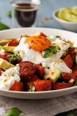 Sweet Potato and Chorizo Hash with egg, avocado and herbs.