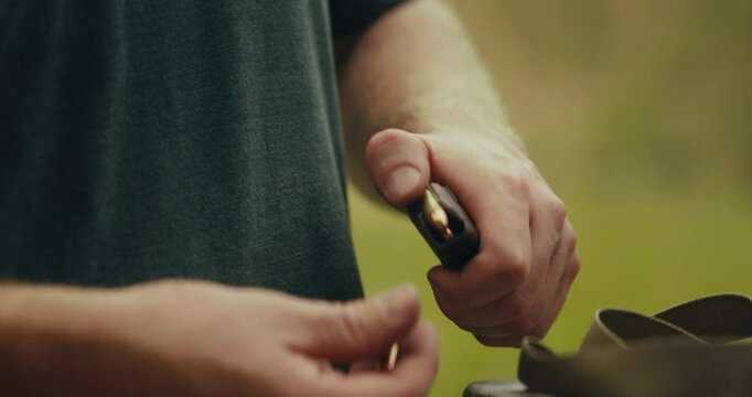 9mm bullets being grabbed and loaded into a magazine
