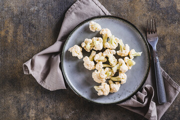Close up of pieces of raw cauliflower for diet on a plate on the table top view