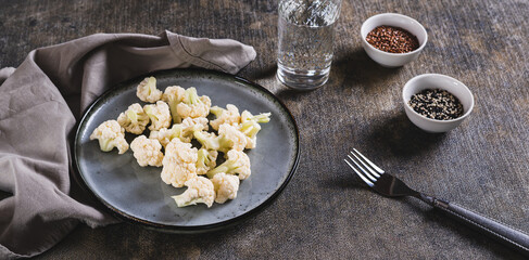 Pieces of raw cauliflower for diet on a plate on the table web banner