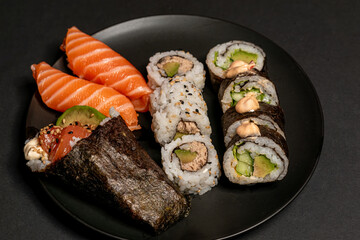 sushi with salmon sushi on the pblack plate,Sushi collection, isolated on black background, medium sushi set on black background, Sushi on a black background