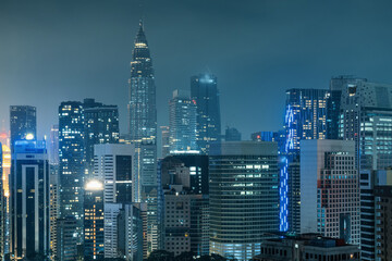 Kuala Lumpur city skyline with twin tower, high-rise buildings and skyscrapers at night, Malaysia. Downtown financial and business center of Asian city with modern architecture