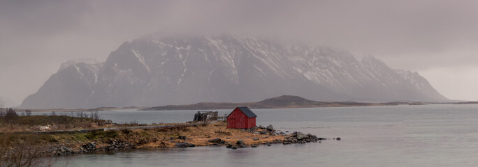 Misty day at a Lofoten shore with traditional red shack