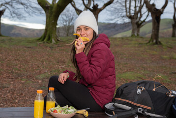 mountaineer woman eating banana in the autumn forest