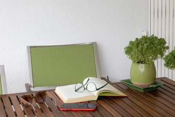 Cozy reading space with book, glasses, and phone on wooden table