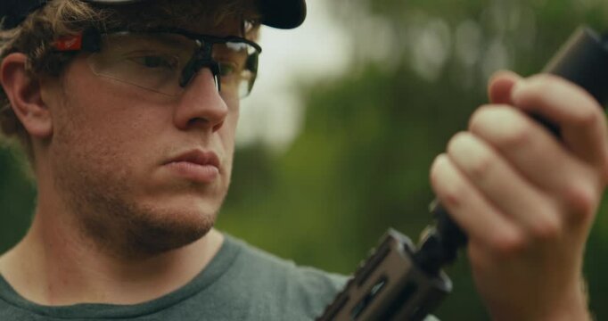 Young man at gun range preparing an AR-15 for use