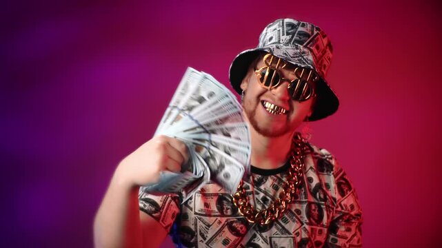 Crazy rap star with dollars and golden accessories looking at camera in studio, golden teeth smile