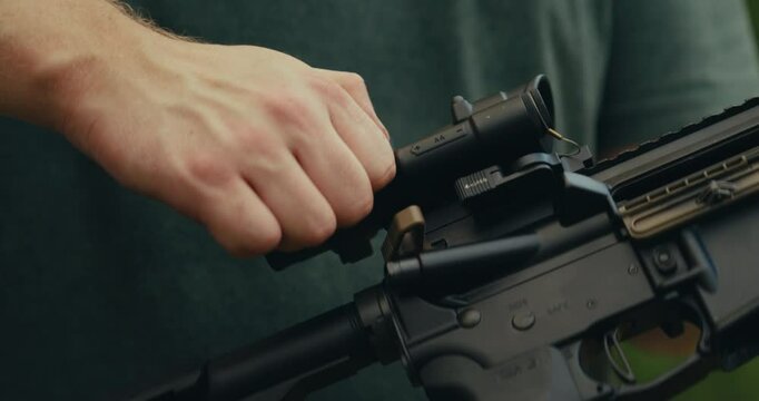 Young man at gun range preparing an AR-15 for use