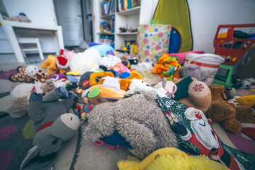 Toys laying on the floor in a kids room. Mess at home. Clining kids toys concept.