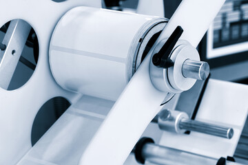 A roll of white paper is passed through the machine. printer and sticker machine, which is used for...