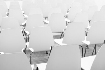Obraz premium A row of empty chairs in a classroom. The chairs are all facing the same direction