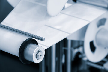 A roll of white paper is passed through the machine. printer and sticker machine, which is used for...