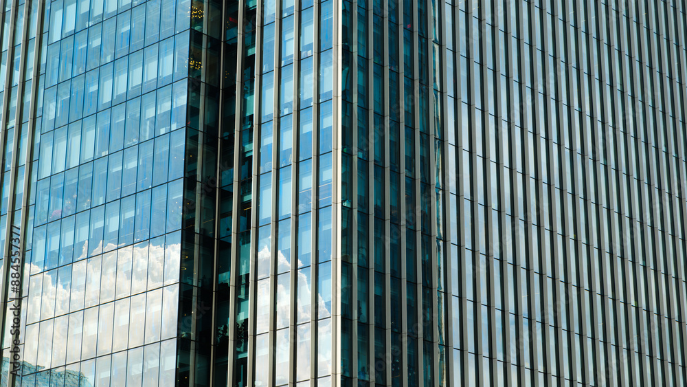 Poster A tall building with many windows and a cloudy sky in the background