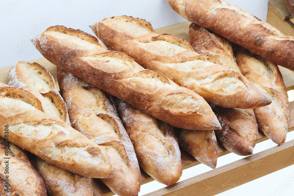 Aufkleber a row of bread loaves are on a wooden shelf. the loaves are all different sizes and shapes, but they