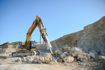 Excavator with hydraulic hammer on road construction works